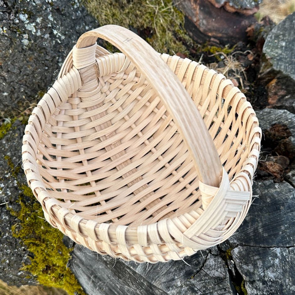 Melon basket sitting on a tree stump, detailed view of the inside of the basket.