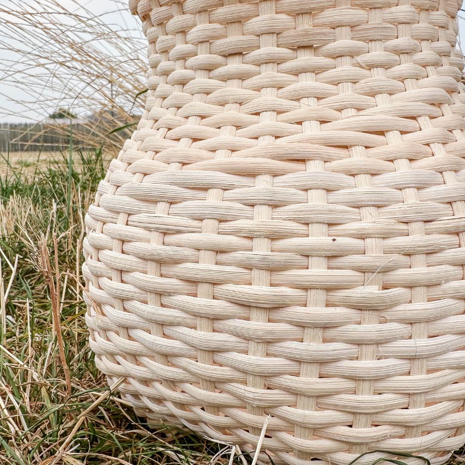 Close up image of a vase shaped basket. The stair step weave detail winds up the basket.