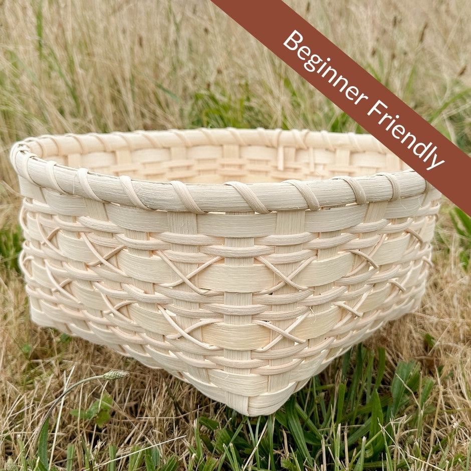 Cross-stitch napkin basket sitting in the grass.