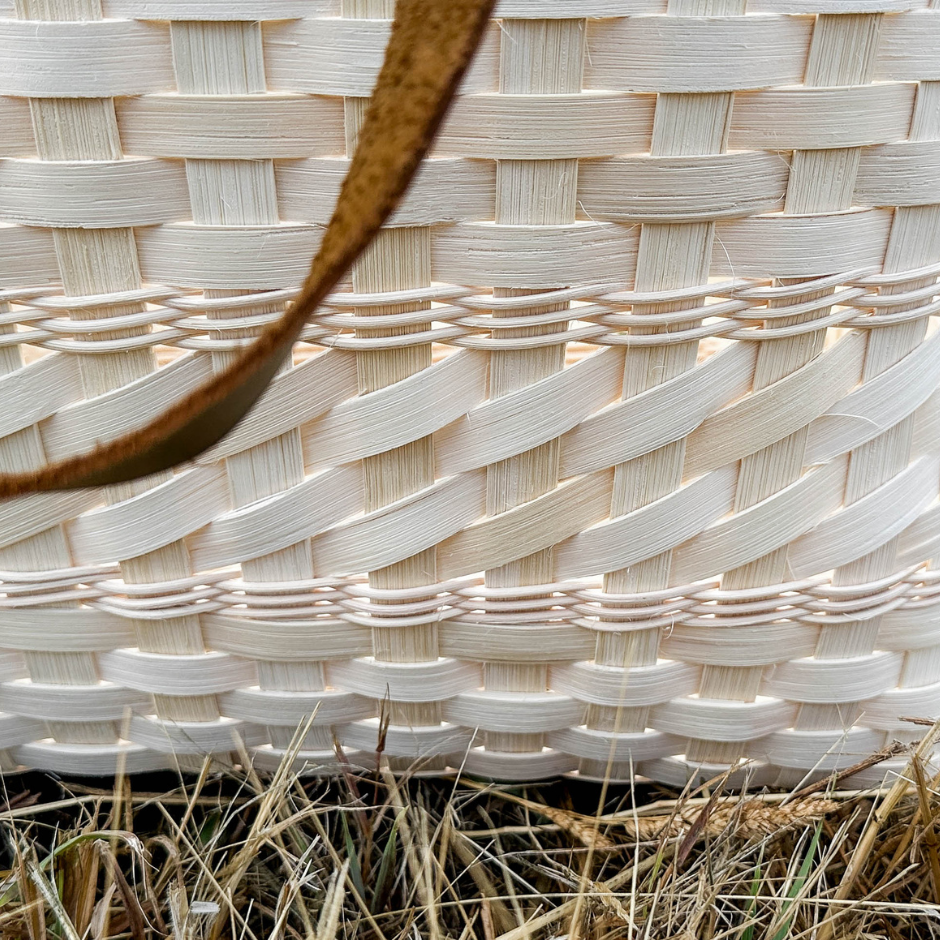 Close-up of a woven basket with natural grasses in the foreground.