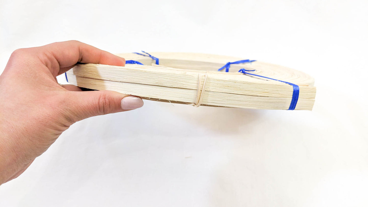 Hand holding a hank of Flat Rattan Reed 3/8" - 1 Pound Coil - Textile Indie