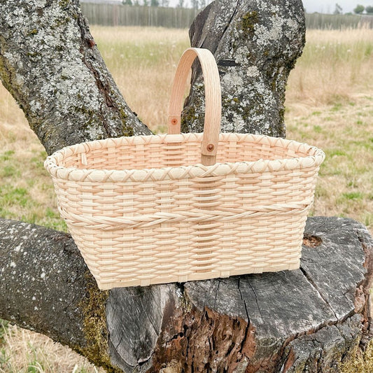 Wicker basket on a wooden log with a natural background.