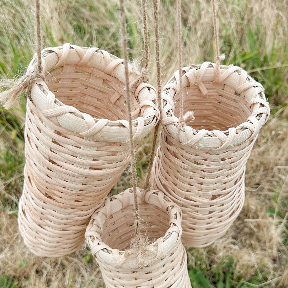 Three hanging Flower Vase Baskets against a grassy backdrop.