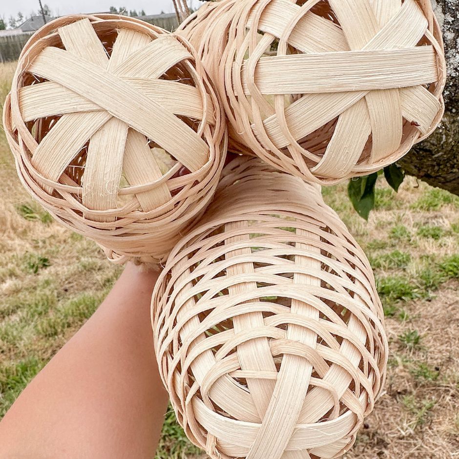 Three woven baskets held by a hand to show the base details. 