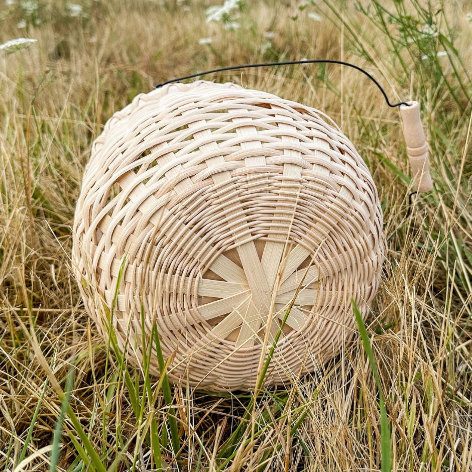 Bottom detail view of a bean post basket sitting in the grass.