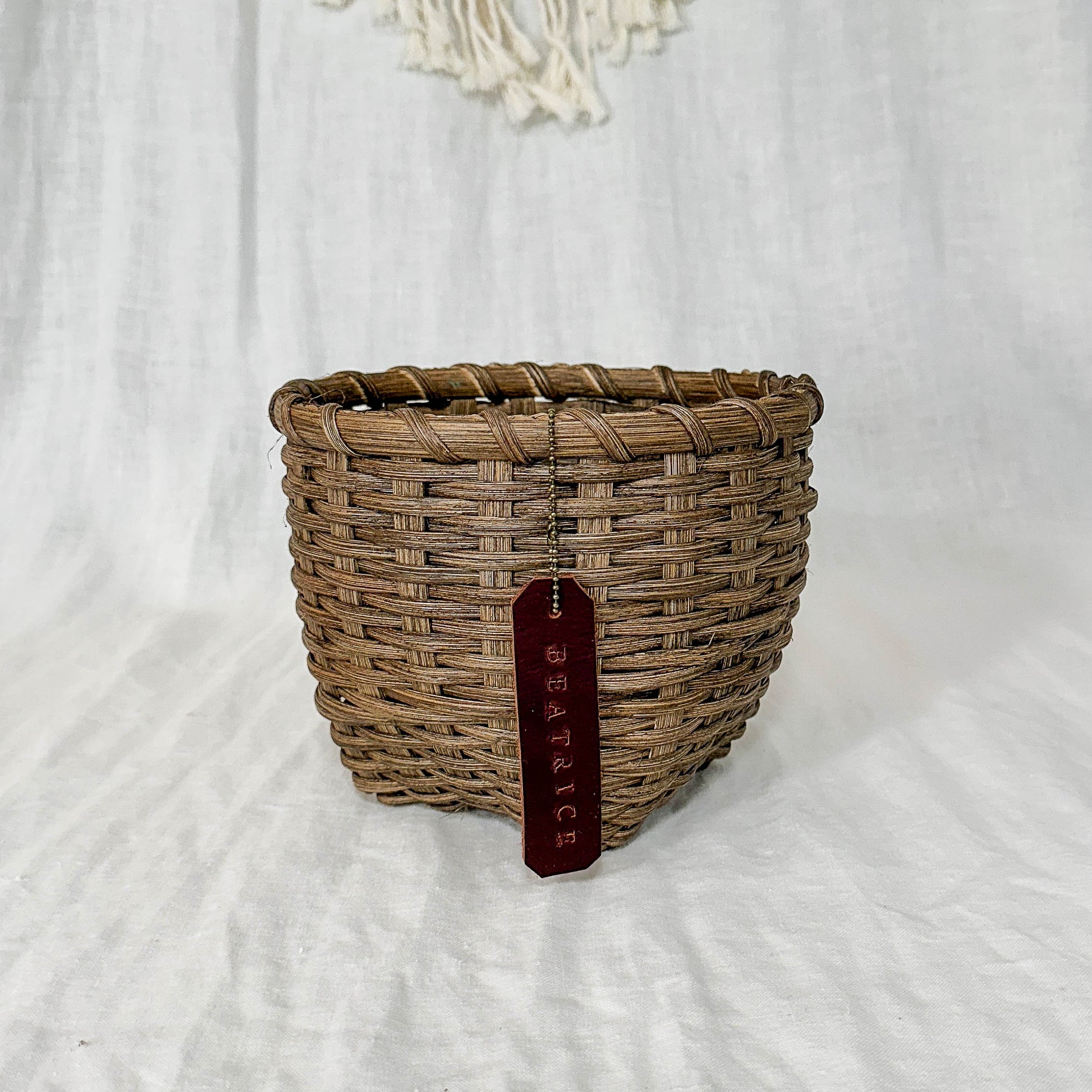 Woven basket with a tag on a white background