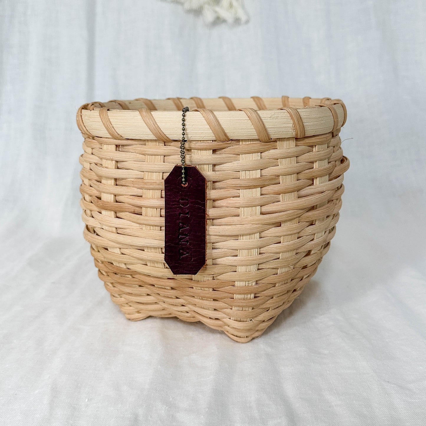 Woven basket with a tag on a white background