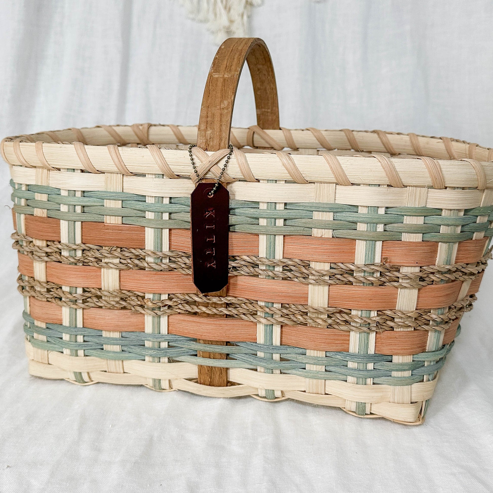 Woven basket with a plaid pattern on a white fabric background