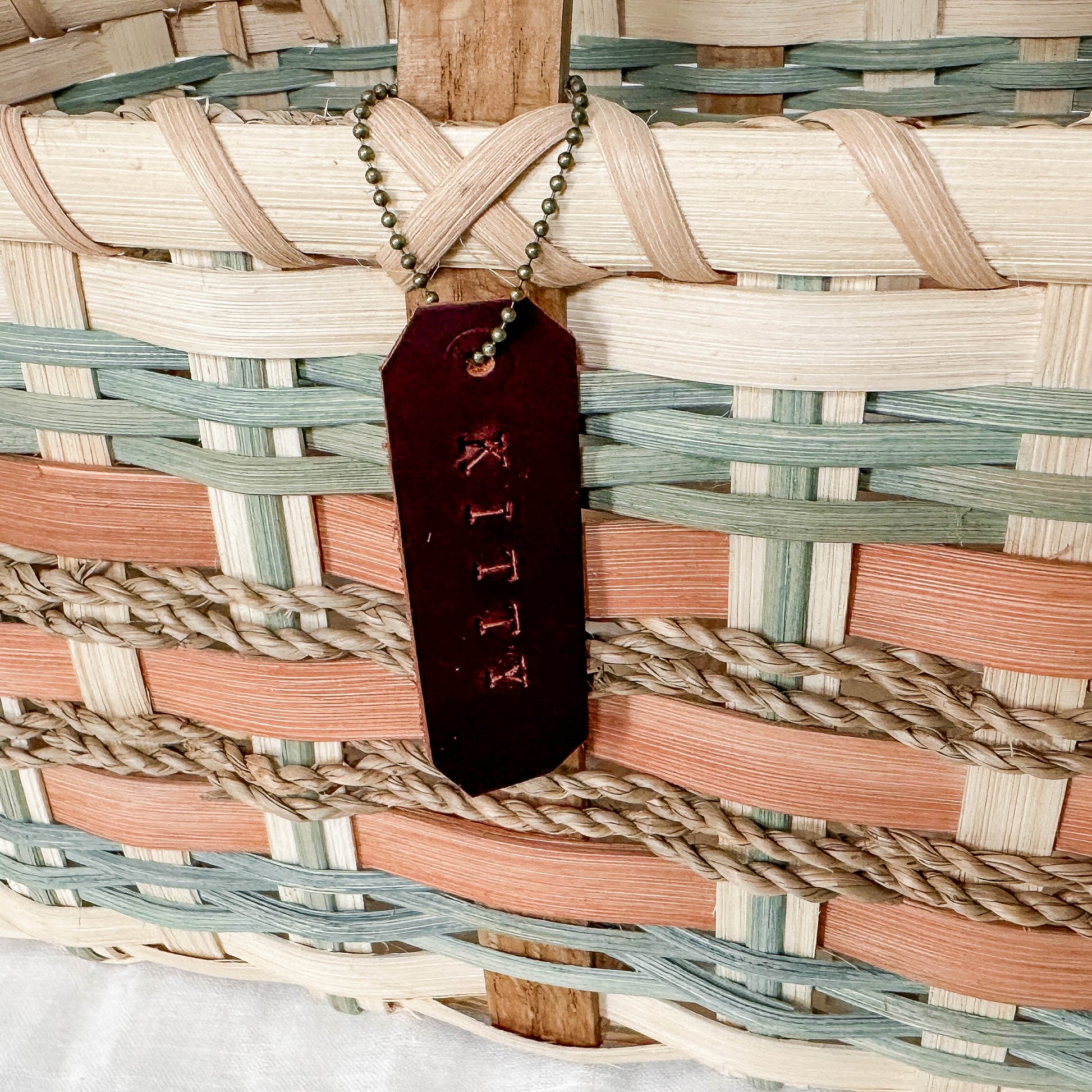 Woven basket with a 'KITTY' tag on a white background