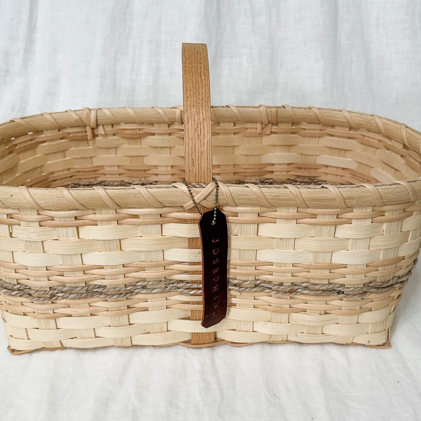 Woven basket with a handle on a white background