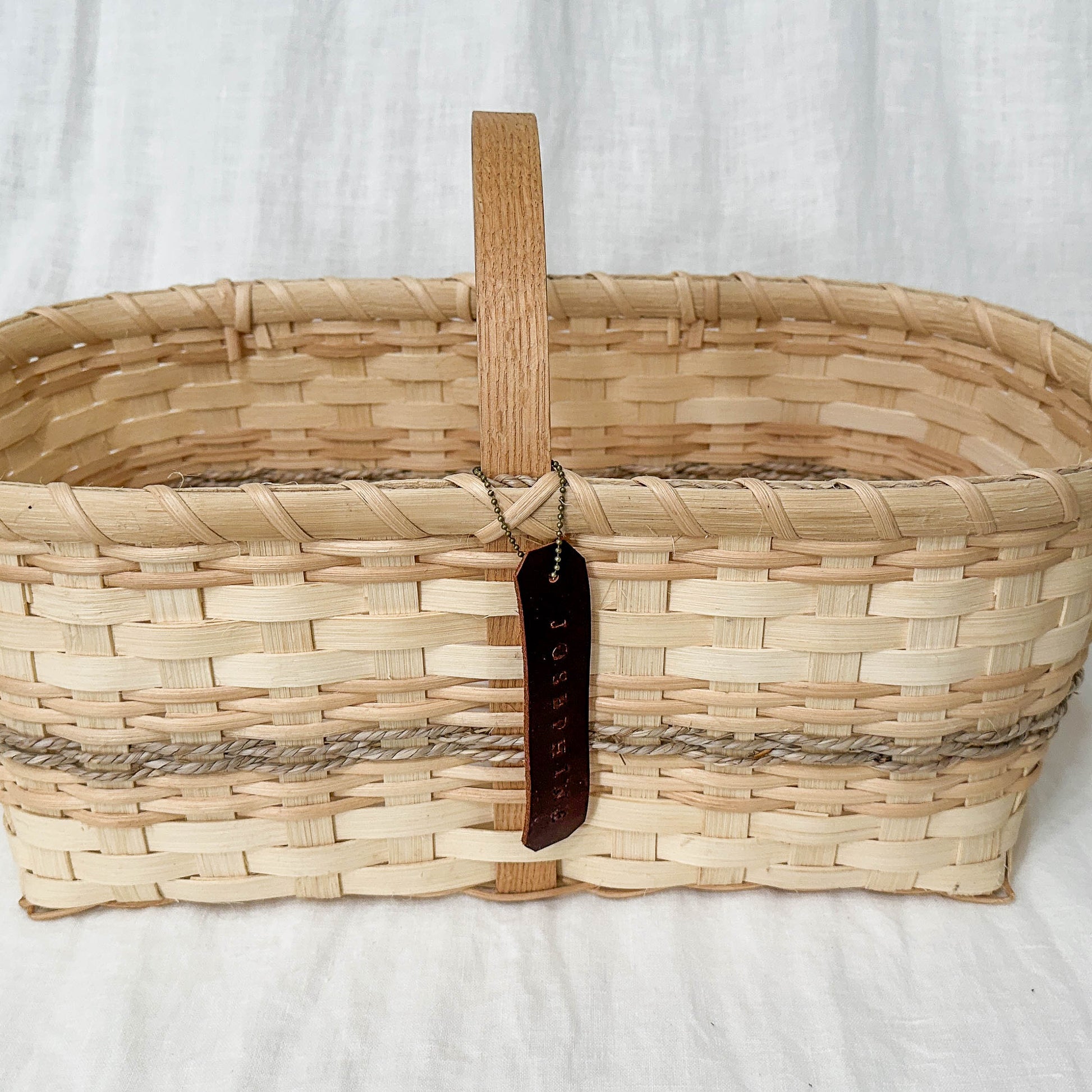 Woven basket with a handle on a white background