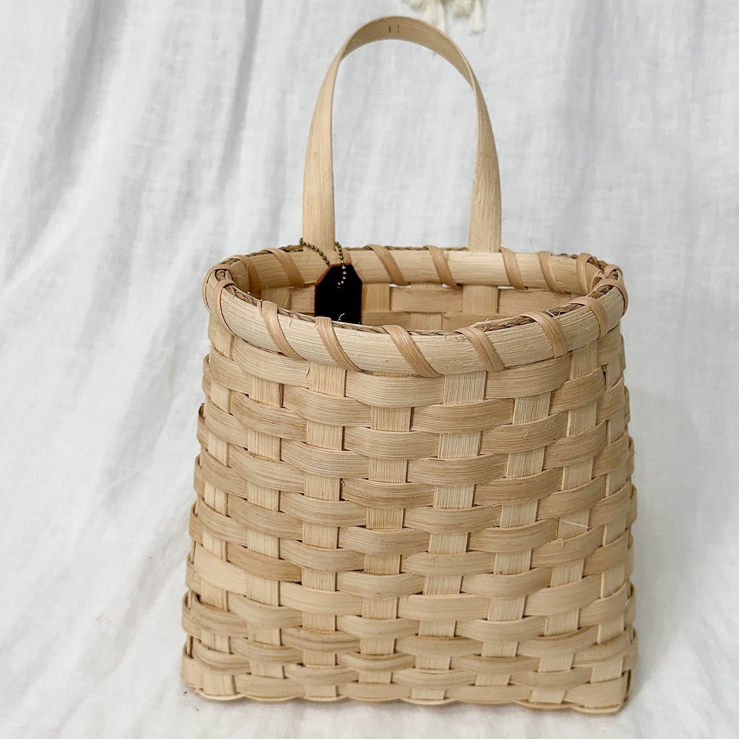 Woven basket with handles on a light gray background