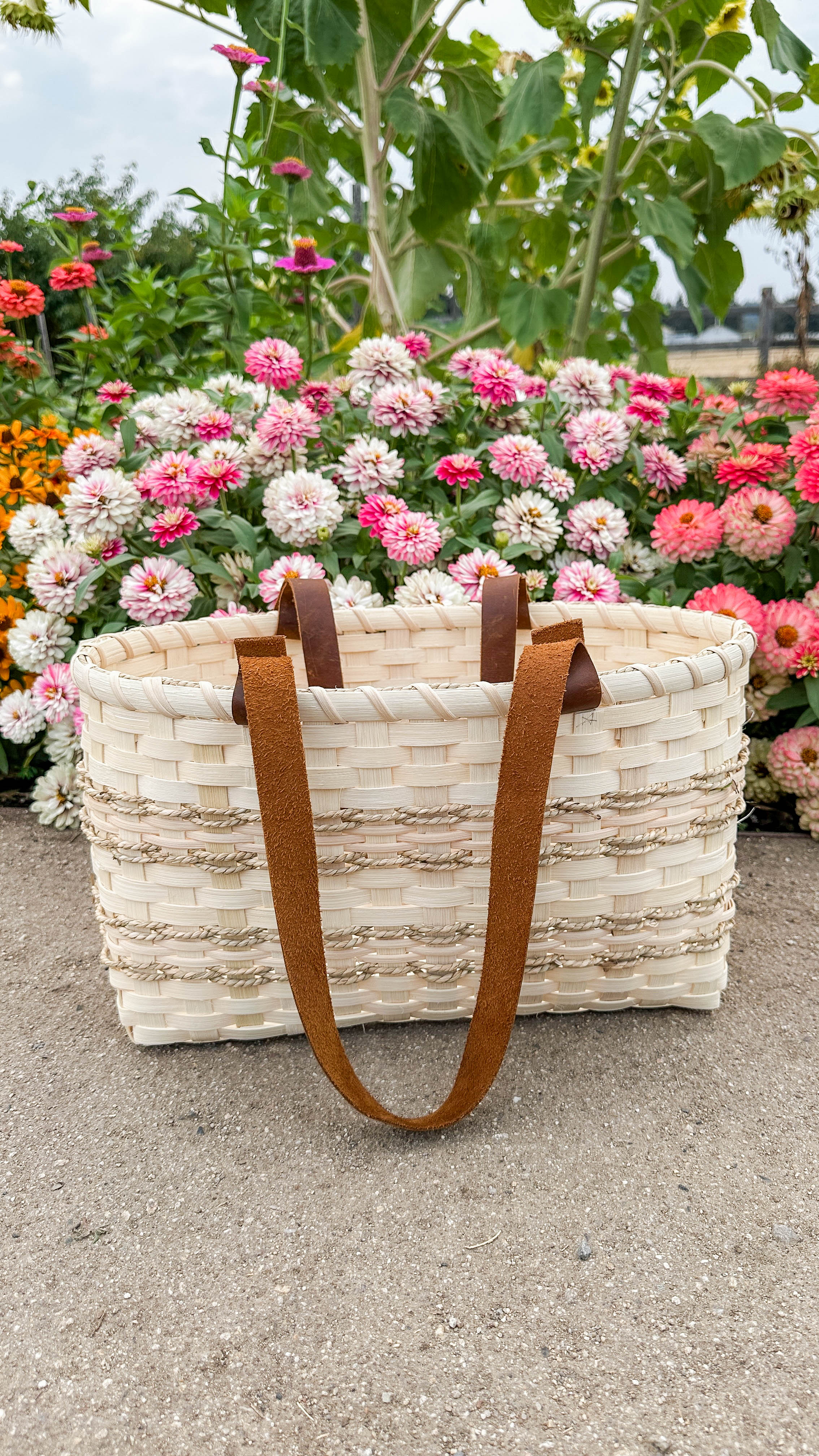 Load video: Woman holding a rattan picnic tote basket.